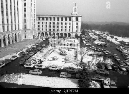 Bucharest, Romania, January 1990. A few weeks after the anti-communist revolution, vehicles parked in front of Casa Scanteii, the building hosting all media and publishing houses during the communist period. Stock Photo