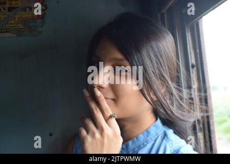 A young Indian women posing for photo in train. Stock Photo