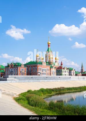 Blagoveshchenskiy Sobor and concrete waterfront of Voskresenskaya embankment of Malaya Kokshaga river in Yoshkar-ola city on sunny summer day Stock Photo