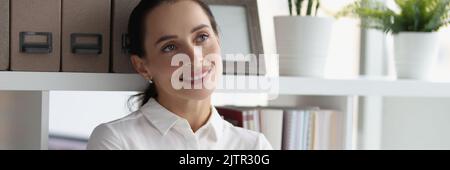 Businesswoman in white blouses standing near rack with folders Stock Photo
