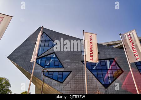 Luneburg, Germany, August 22, 2022: Main building of Leuphana University with Audimax and flags in the foreground, architect Daniel Libeskind Stock Photo