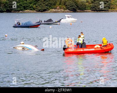 Local Harbour Master removing sunken yacht towing it away from mooring with Waly Boat Stock Photo