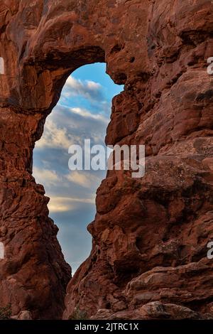 A morning sky peeks through Turret Arch at Arches National Park, Grand County, Utah Stock Photo