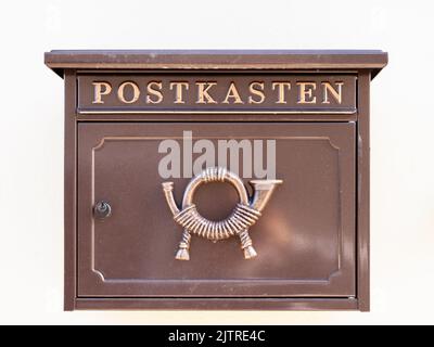 An old vintage rusty mailbox hanging on a white wall Stock Photo