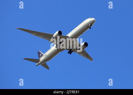Passenger Jet Aeroplane flying directly above in a bright blue sky Stock Photo