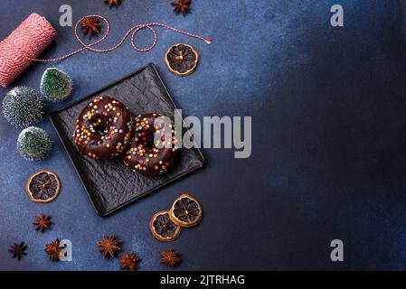 Pastries concept. Donuts with chocolate glaze with sprinkles, on a dark concrete table. Sweet food for a breakfast Stock Photo