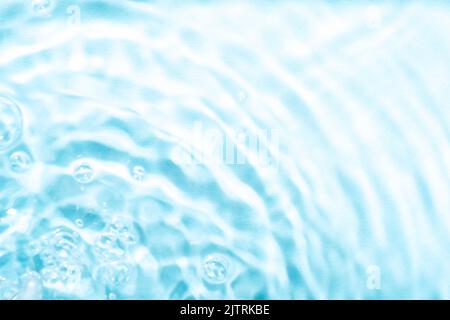 Defocused blurred ripples in blue water. Texture, background. Stock Photo