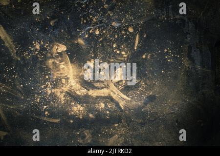 Dark stained abstract background. Rust dust. Golden smeared powder on black surface. Stock Photo