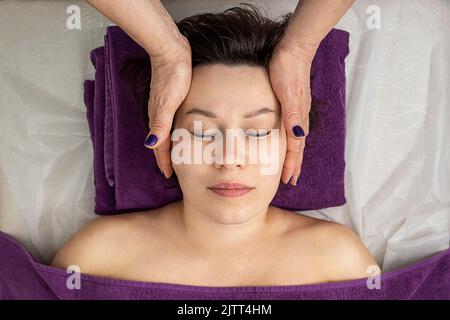 Facial massage. Close-up of an adult woman getting a spa massage at a beauty spa Stock Photo