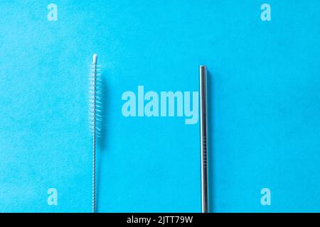 reusable stainless steel straws and cleaning brush on blue background, eco friendly lifestyle, copy space, top view, flat layout. Stock Photo