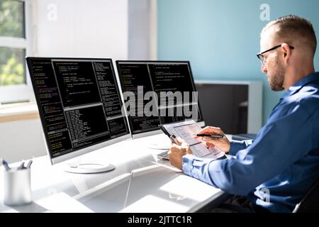 Computer Programmer Writing Program Code On Computer In Office Stock Photo