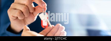 Cropped Image Of Estate Agent Giving House Keys In Office Stock Photo