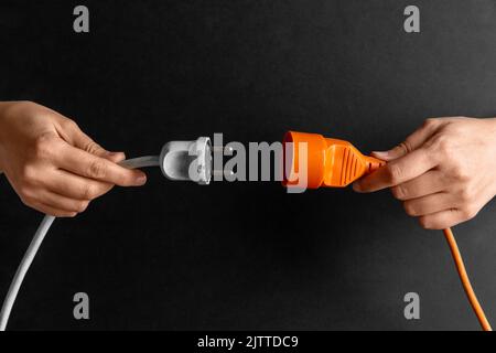 close up of woman inserting plug into socket Stock Photo