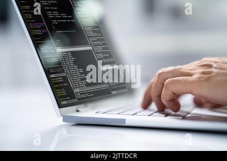 Computer Programmer Using Development Software On Laptop Stock Photo