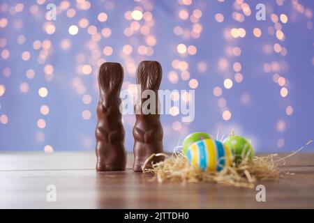 easter eggs in straw nest and chocolate bunnies Stock Photo