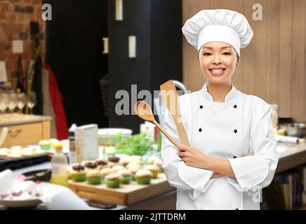happy smiling female chef with wooden spoon Stock Photo