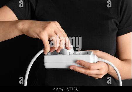 close up of woman inserting plug into socket Stock Photo