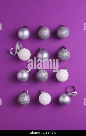 Christmas baubles arranged on purple background. Top view. Stock Photo