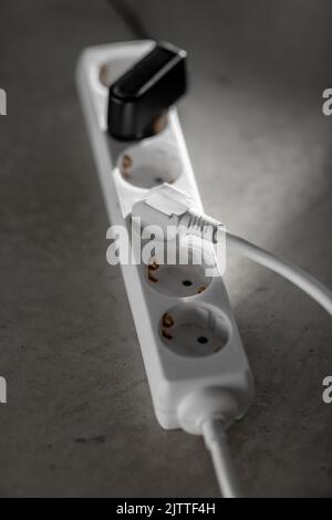 close up of socket with plugs and charger on floor Stock Photo