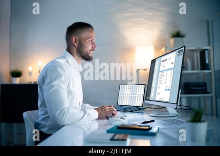 Workaholic Working On Desktop Computer At Night Stock Photo
