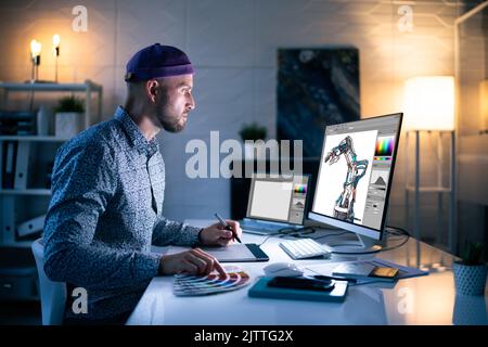 Graphic Designer Working Late At Night In Office Stock Photo