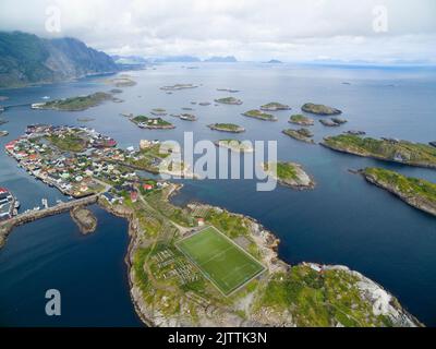 Aerial view, Henningsvaer with football pitch, rocky islands in the sea ...