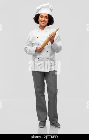 smiling female chef or baker with rolling pin Stock Photo