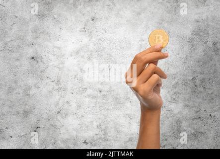 close up of hand with bitcoin over white Stock Photo