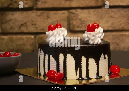Chocolate Vanilla Cake with cherries on top Stock Photo