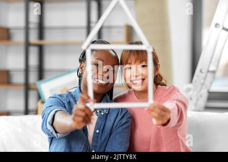 happy smiling women with ruler in shape of house Stock Photo