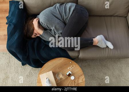 depressed woman lying on sofa at home Stock Photo