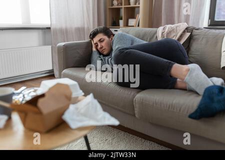 depressed woman lying on sofa at home Stock Photo