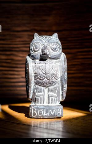 Close up of traditional bolivian owl statuette isolated on wooden background. Vertical Image Stock Photo