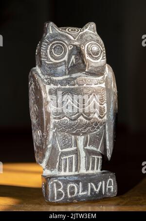 Close up of traditional bolivian owl statuette isolated on wooden background. Vertical Image Stock Photo