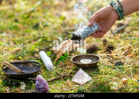 woman or witch performing magic ritual in forest Stock Photo