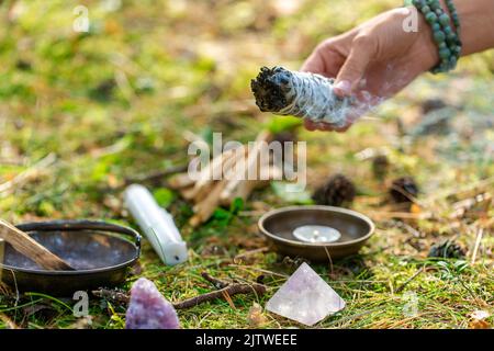 woman or witch performing magic ritual in forest Stock Photo