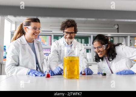 scientists with chemicals working in laboratory Stock Photo