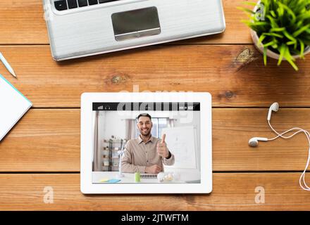 tablet pc with male teacher or blogger on screen Stock Photo
