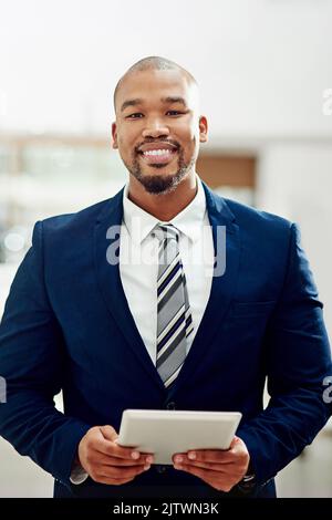 Im turning my visions into profits. Cropped portrait of a smiling businessman using his tablet in the office. Stock Photo