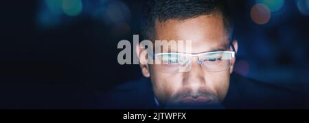 Thinking, research and business man working late on online project in a dark corporate office. Serious data analyst searching the internet, planning a Stock Photo