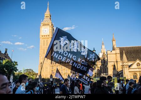 London, UK. 31st Aug, 2022. Protesters wave a banner in front of the Palace of Westminster during the demonstration. Protesters gathered in London on the third anniversary of the Hong Kong police entering a metro station and beating protesters and commuters, an event that pro-democracy activists say exemplify the impunity and abuse of the Hong Kong police. Credit: SOPA Images Limited/Alamy Live News Stock Photo