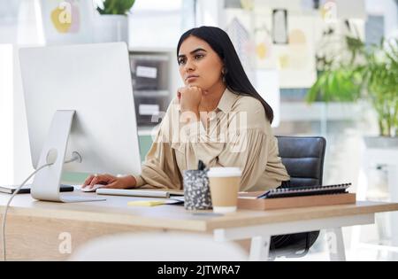 Thinking, attention and business woman on computer working by desk in design company office building. Idea, vision and innovation with employee Stock Photo