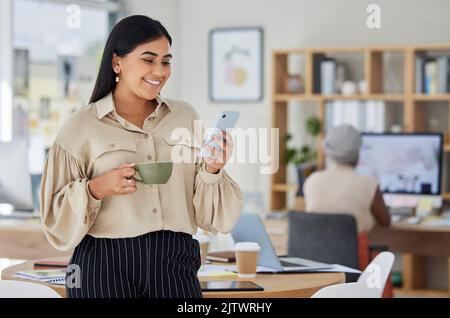 Happy marketing manager texting on phone, advertising small business startup on social media and drinking a coffee. Young professional woman browsing Stock Photo
