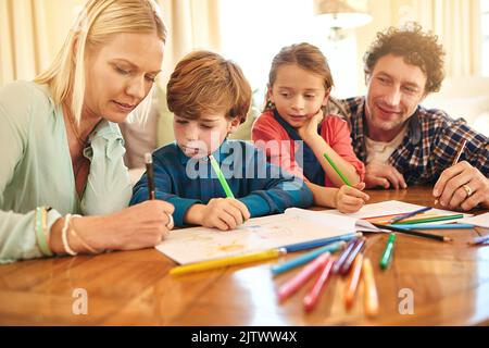 Sparking creativity. a family drawing and colouring in pictures together at home. Stock Photo