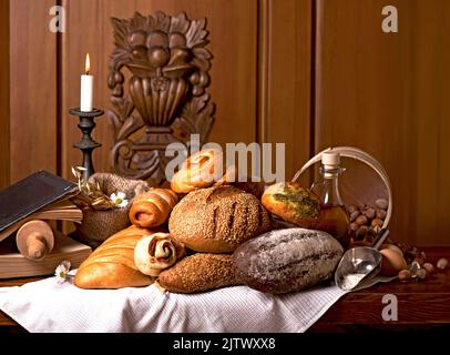 Bakery products of various types. Wicker basket with different types of bread on a wooden table. Stock Photo