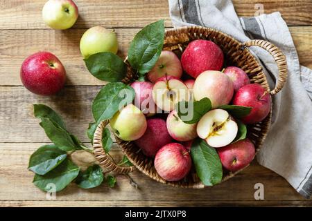 Fall harvest background. Organic fruits. Farmer's market. Basket of ripe apples on a rustic wooden table. View from above. Stock Photo