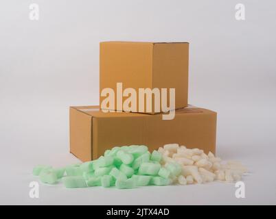 corrugated parcel boxes with shockproof bubbly plastic protective granules on white background, online business concept. Stock Photo