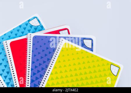 Colored notebooks on a white background with copy space. New notebooks for a student. Stock Photo