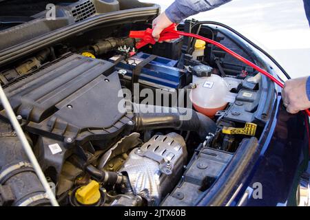 broken down car with low battery. Starting with cables Stock Photo