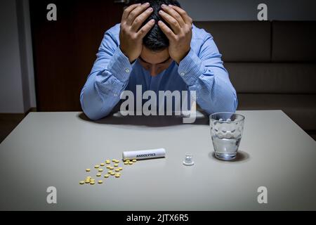 lonely boy at home with anxiolytic pills. Problem of the new millennium of anxiety, generalized anxiety and panic attacks Stock Photo